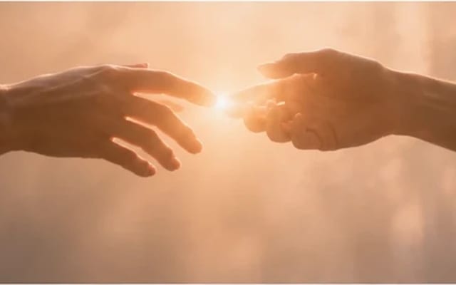 Duas mãos se aproximando com ternura na luz, um brilho quente entre elas — emoção intensa acolhida com compaixão